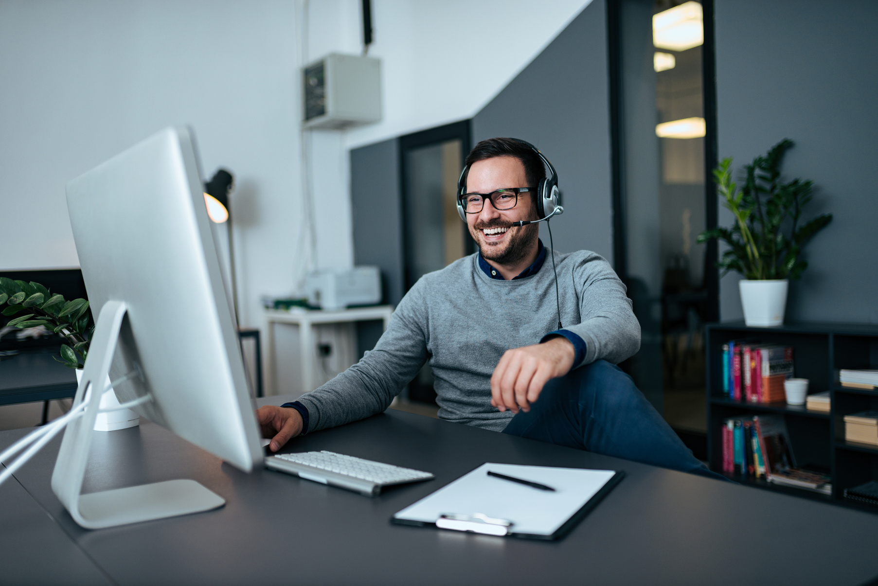 Handsome casual businessman talking online via headset.